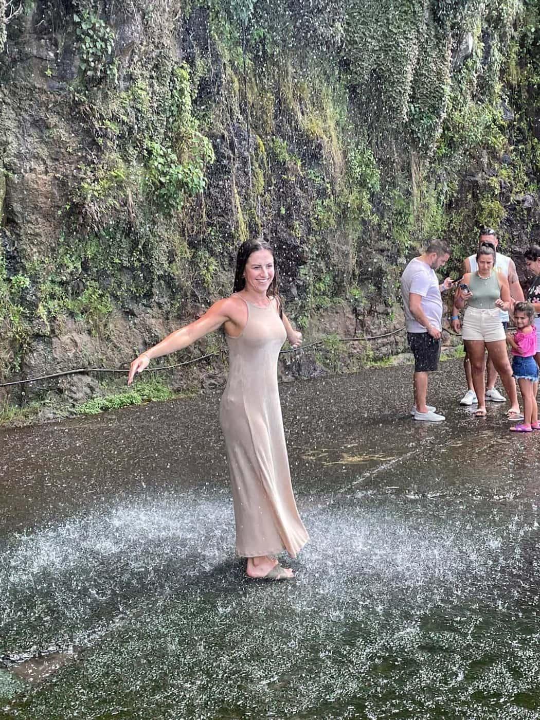 Cascata dos Anjos waterfall flowing over the coastal road in Ponta do Sol, Madeira