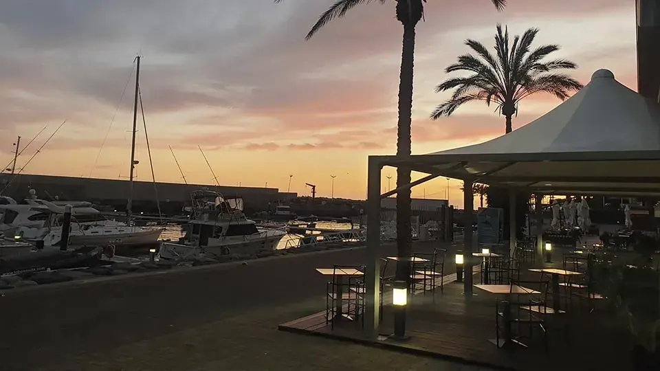 Leme Marisqueira terrace beside boats at Calheta Marina at sunset